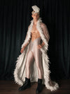 Three-quarter view of a male model wearing the white feather cape and headpiece set, showing the feather-trimmed opening and trailing hem